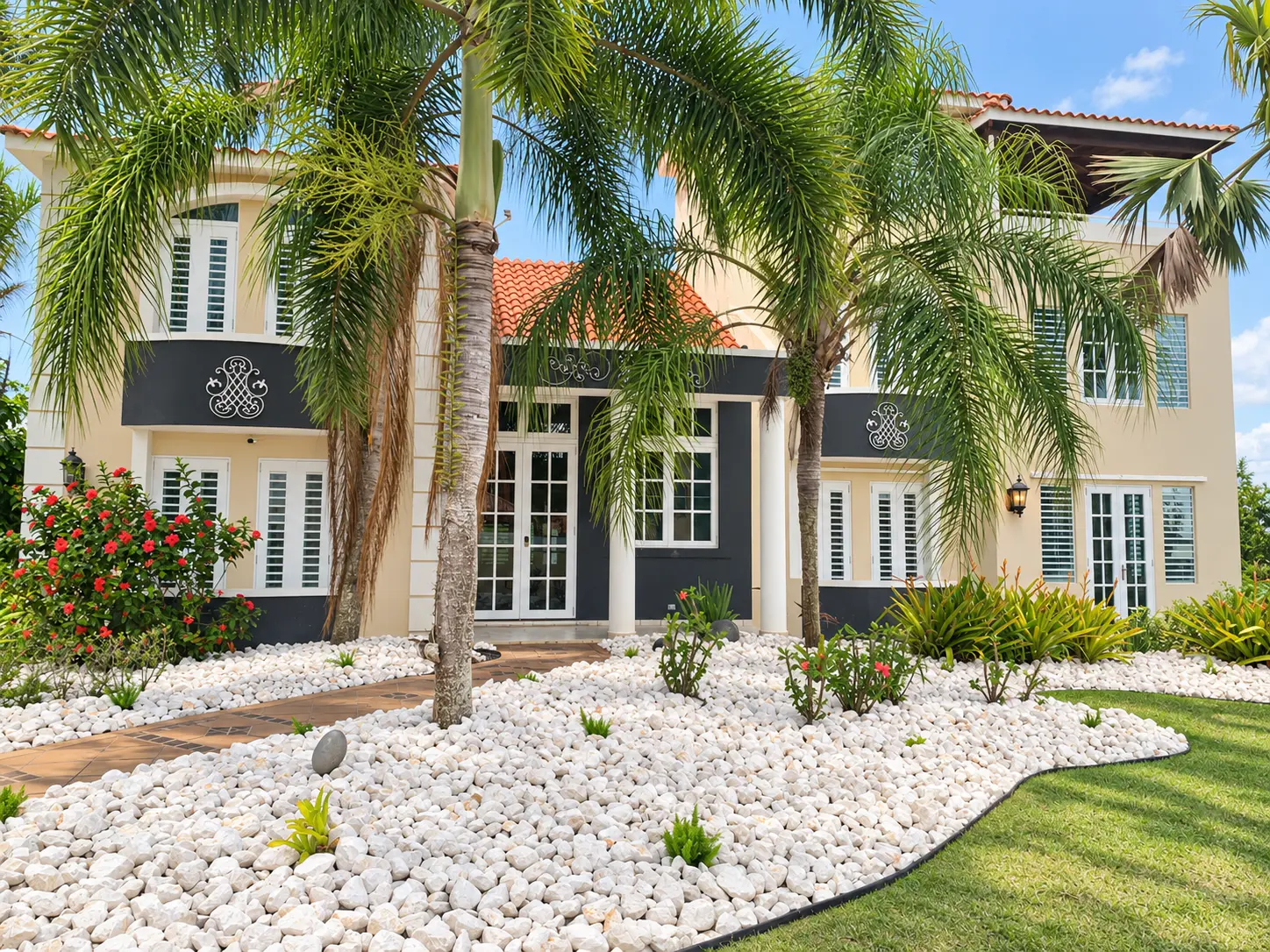 Front entrance of Majestic Oasis framed by palms and white-stone landscaping
